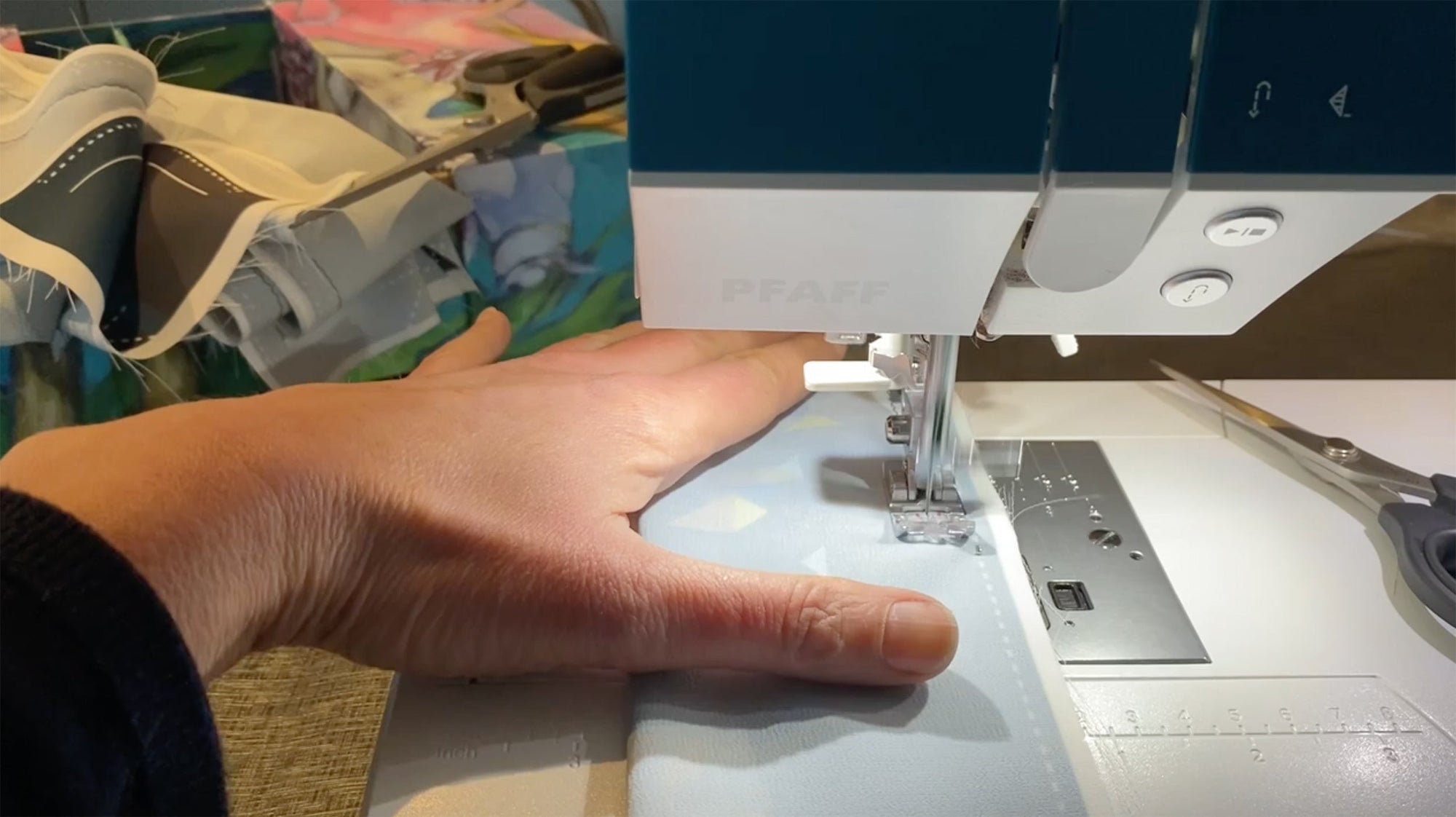 Ottimare aan het werk om een handgemaakte sjaal te maken op de naaimachine.