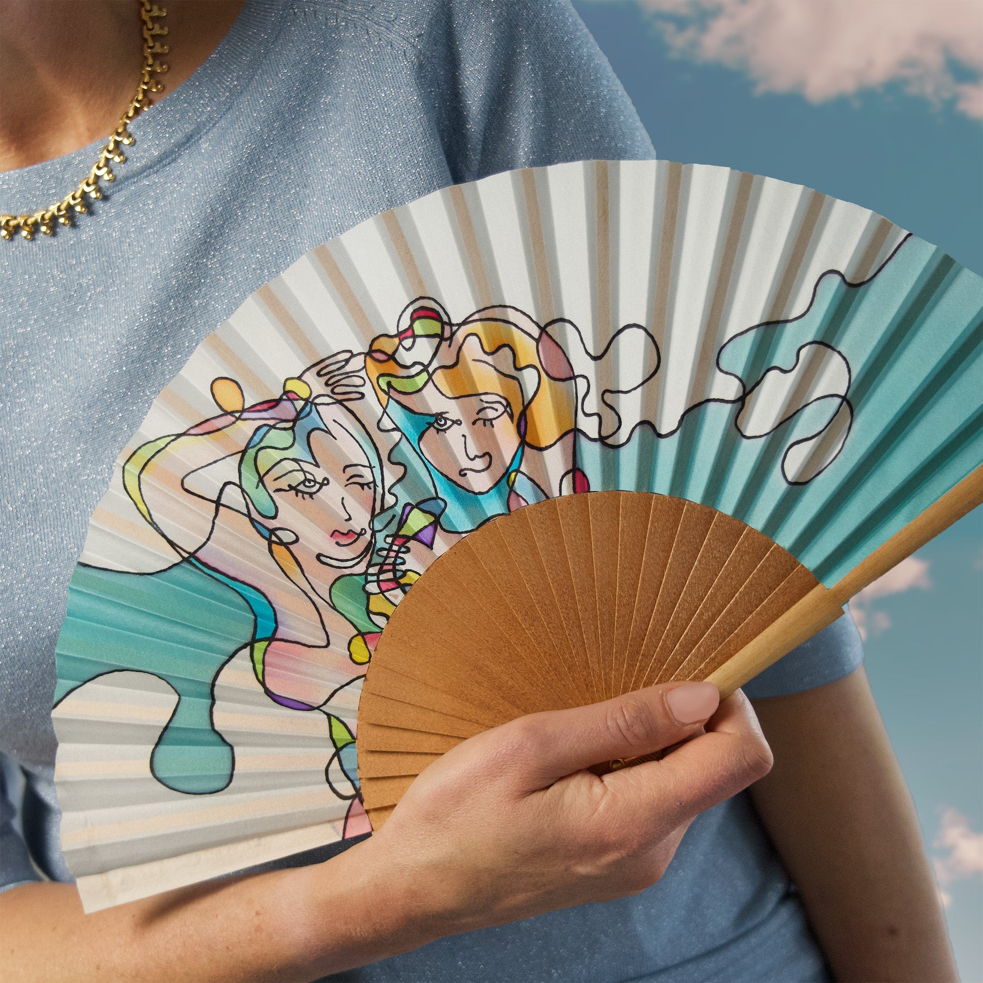 Zijden waaier van Ottimare met model. De waaier heeft aqua en heldere pastkleuren en is handbeschilderd.