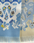 Detail van de Ottimare frilly dames sjaal met jasmijnen in hemels blauw en geel. Handgemaakt in Nederland van duurzame kunst zijde met twill weving. De sjaal is duo-face met twee kanten en heeft een franje.