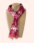 Ottimare red and orange floral patterned scarf on a mannequin with a beige background. Hand-made in the Netherlands from sustainable twill fabric.