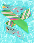 Cool Caribbean twilly van Tencel twill van Ottimare met one-line tekeningen van schoenen en frisse strepen. Op de achtergrond is zwembad water te zien.