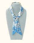Ottimare floral twilly ladies scarf with jasmines on a mannequin in celestial blue and yellow. This ribbon tie is handmade in the Netherlands from sustainable twill art silk.