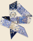 Ottimare twilly scarf with pattern of jasmine flowers with two different sides. Made from sustainable twill eco silk in dark and medium future blue with white and sand accents. Handmade in Holland. One scarf, two sides.