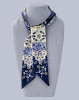 Navy and future blue and white patterned Ottimare twilly scarf on a mannequin. The ribbon tie has yellow accents and is handmade from sustainable eco twill in Made and designed in The Netherlands.