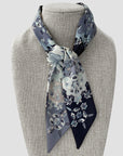 Ottimare floral Twilly scarf on a mannequin with black and grey jasmin flowers. Handmade from eco art twill silk in the Netherlands. Double layered, two different sides and colors.