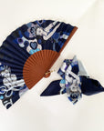 Ottimare waaier met bijpassende twilly sjaal met twee Thangka dansers tegen een donkerblauwe achtergrond met een Spaans houten frame in warm bruine kleur met een goudkleurige ring.