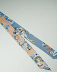 Long ribbon scarf with four different dansers with different sides. One side in celestial blue the other in apricot. The details have several accents in orange and yellow. Designed and handmade by Ottimare.