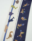 Deatil of Long tangram scarf Ottimare one dusk blue side and ivory on the back side with multicolored tangram figures.