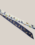 Long tangram scarf Ottimare one dusk blue side and ivory on the back side with multicolored tangram figures.