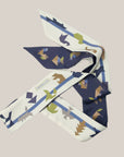 Lange tangram sjaal van Ottimare met een dusk blauwe en een ivoor kleurige achtergrond. De figuurtjes zijn in grijs, groen, camel en blauwe tinten.