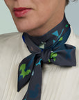 Grey and petrol green tangram scarf on a model. Extra long ribbon cravat, wrapped twice with a bowtie. Ottimare.
