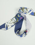 Skinny ribbon scarf from Ottimare with a Thangka dancer in future middle blue with fresh green and yellow and small pink accents. Dutch design, made in the Netherlands
