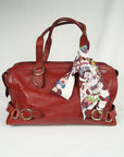 Lange bordeaux sjaal met Thangka dansers van Ottimare bevestigt aan een rode handtas. Dutch design.