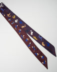Full picture of extra long ribbon scarf in burgundy - bordeaux - on one side, and eggplant - aubergine color - on the other. Tangram figures in multi color blue, gold, camel, ivory. Ottimare
