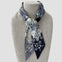Ottimare floral Twilly scarf on a mannequin with black and grey jasmin flowers. Handmade from eco art twill silk in the Netherlands. Double layered, two different sides and colors.
