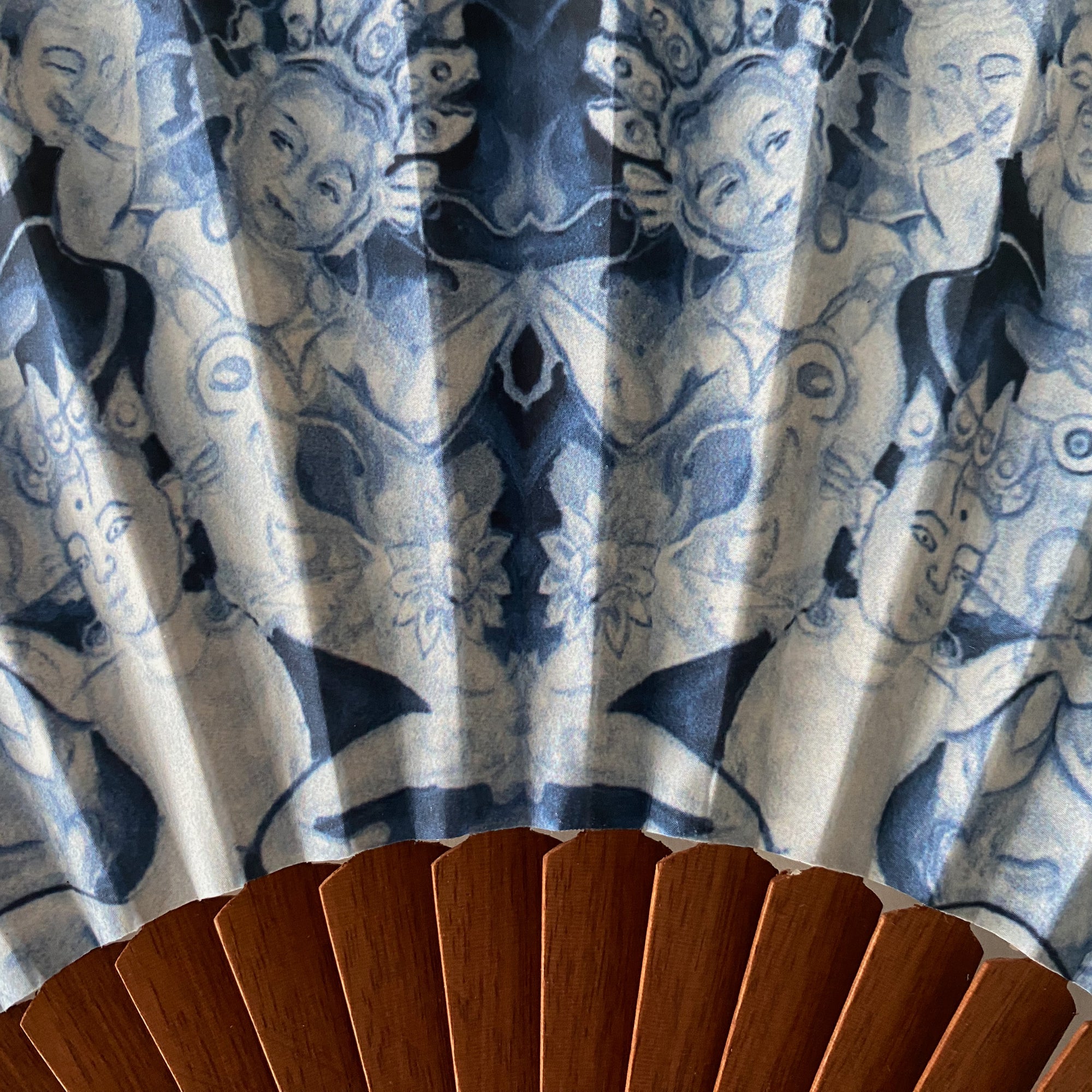 Detail van duurzame Ottimare  waaier met stof waarop een blauwdruk van Thangka dansers op artisanaal houten Spaans waaierframe