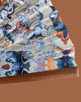 detail van waaier van Ottimare met blauw en sienna print op duurzame zijde. De waaier is artisanaal opgespannen op een AEA kwaliteit houten frame in Spanje.
