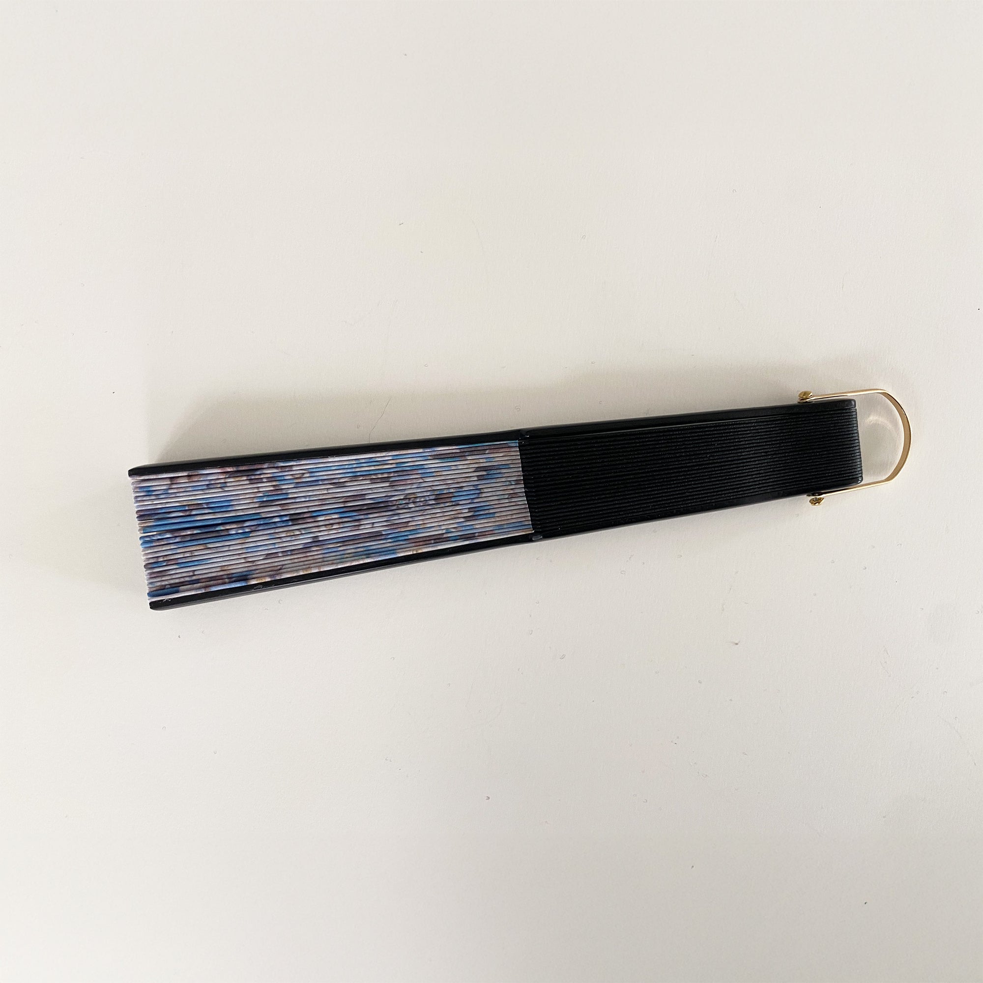 Nederlands ontwerp op een waaier van Ottimare met zand en blauwe tinten op duurzame kunst zijde. De stof is artisanaal opgespannen op een zwart gelakt berkenhouten frame met goudkleurige ring.